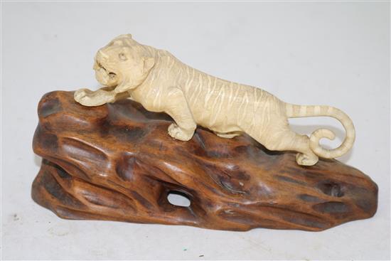 A Japanese ivory figure of a prowling tiger, Meiji period, length 26cm incl. carved wood stand